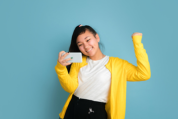 Image showing Asian teenager\'s portrait isolated on blue studio background