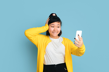 Image showing Asian teenager\'s portrait isolated on blue studio background