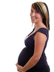 Image showing Smiling pregnant woman holding belly in dress