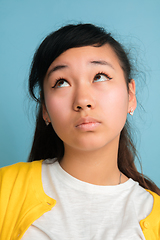 Image showing Asian teenager\'s close up portrait isolated on blue studio background