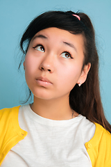 Image showing Asian teenager\'s close up portrait isolated on blue studio background