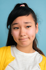 Image showing Asian teenager\'s close up portrait isolated on blue studio background