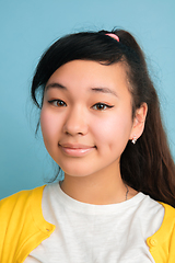 Image showing Asian teenager\'s close up portrait isolated on blue studio background