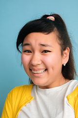 Image showing Asian teenager\'s close up portrait isolated on blue studio background