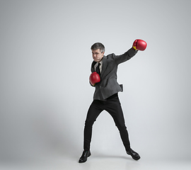 Image showing Caucasian man in office clothes boxing isolated on grey studio background