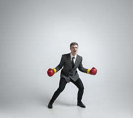 Image showing Caucasian man in office clothes boxing isolated on grey studio background