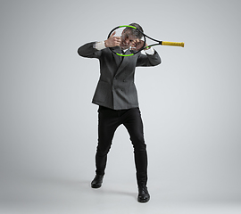 Image showing Caucasian man in office clothes plays tennis isolated on grey studio background