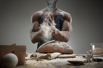 Image showing Close up of african-american man cooks bread at craft kitchen