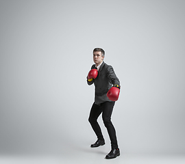 Image showing Caucasian man in office clothes boxing isolated on grey studio background