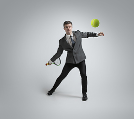 Image showing Caucasian man in office clothes plays tennis isolated on grey studio background