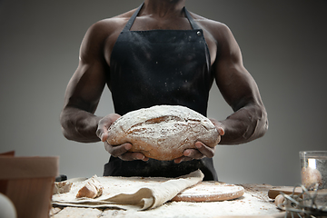 Image showing Close up of african-american man cooks bread at craft kitchen