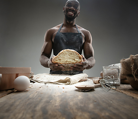 Image showing Close up of african-american man cooks bread at craft kitchen