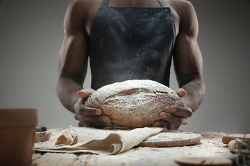 Image showing Close up of african-american man cooks bread at craft kitchen