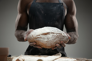 Image showing Close up of african-american man cooks bread at craft kitchen