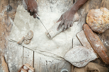 Image showing Top view of african-american man cooks bread at craft kitchen