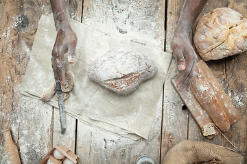 Image showing Top view of african-american man cooks bread at craft kitchen