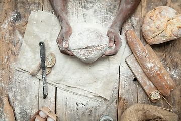 Image showing Top view of african-american man cooks bread at craft kitchen