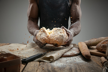 Image showing Close up of african-american man cooks bread at craft kitchen