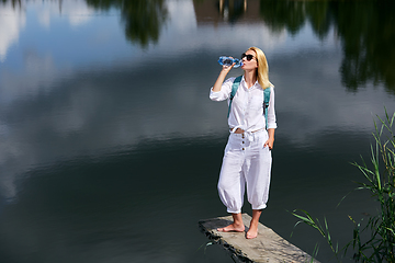 Image showing Young woman resting near lake