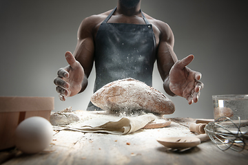 Image showing Close up of african-american man cooks bread at craft kitchen