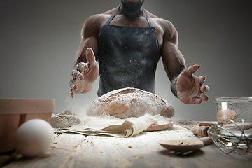 Image showing Close up of african-american man cooks bread at craft kitchen