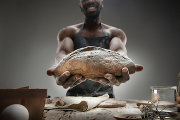 Image showing Close up of african-american man cooks bread at craft kitchen