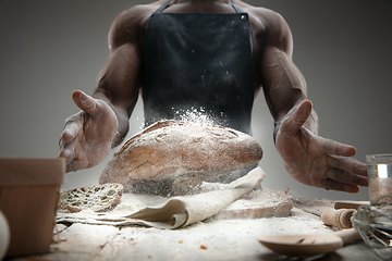 Image showing Close up of african-american man cooks bread at craft kitchen