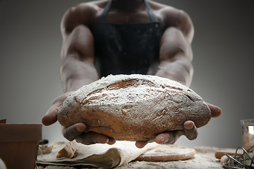 Image showing Close up of african-american man cooks bread at craft kitchen