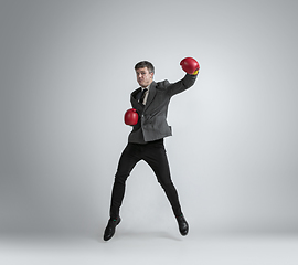 Image showing Caucasian man in office clothes boxing isolated on grey studio background