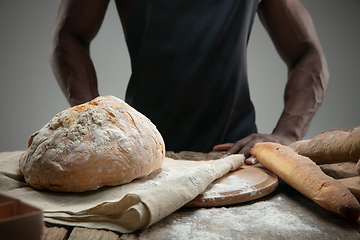 Image showing Close up of african-american man cooks bread at craft kitchen