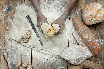 Image showing Top view of african-american man cooks bread at craft kitchen