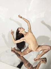 Image showing Young and stylish modern ballet dancer on white background with mirrors