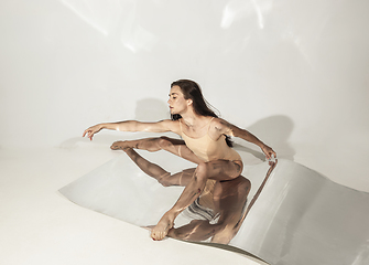 Image showing Young and stylish modern ballet dancer on white background with mirrors