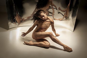 Image showing Young and stylish modern ballet dancer on white background with mirrors