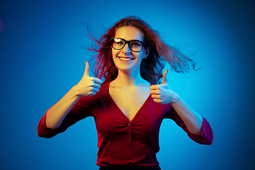 Image showing Caucasian woman\'s portrait isolated on blue studio background in neon light