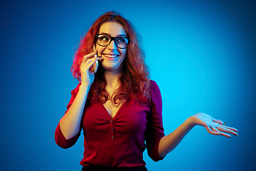 Image showing Caucasian woman\'s portrait isolated on blue studio background in neon light