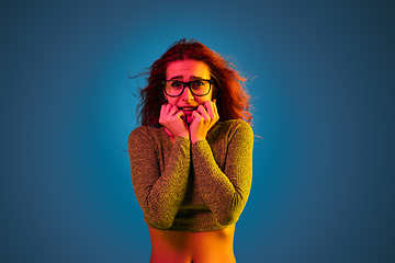 Image showing Caucasian woman\'s portrait isolated on blue studio background in neon light