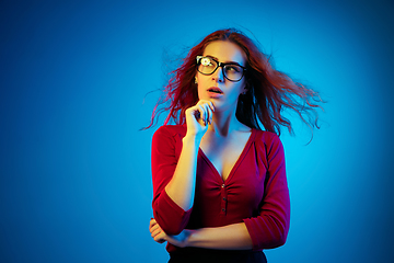 Image showing Caucasian woman\'s portrait isolated on blue studio background in neon light