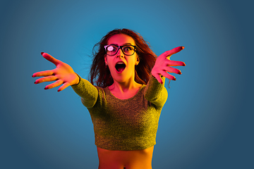 Image showing Caucasian woman\'s portrait isolated on blue studio background in neon light