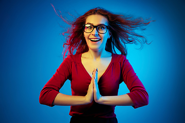 Image showing Caucasian woman\'s portrait isolated on blue studio background in neon light