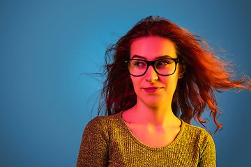 Image showing Caucasian woman\'s portrait isolated on blue studio background in neon light