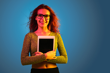 Image showing Caucasian woman\'s portrait isolated on blue studio background in neon light