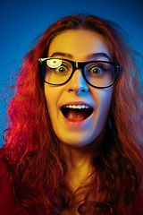 Image showing Caucasian woman\'s portrait isolated on blue studio background in neon light