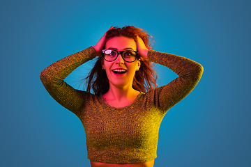 Image showing Caucasian woman\'s portrait isolated on blue studio background in neon light