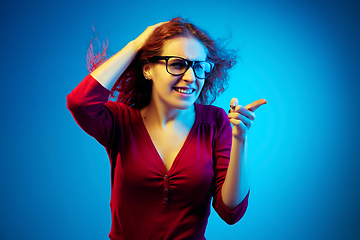 Image showing Caucasian woman\'s portrait isolated on blue studio background in neon light