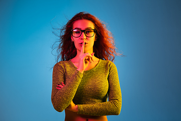 Image showing Caucasian woman\'s portrait isolated on blue studio background in neon light