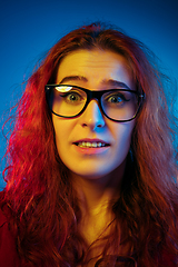 Image showing Caucasian woman\'s portrait isolated on blue studio background in neon light