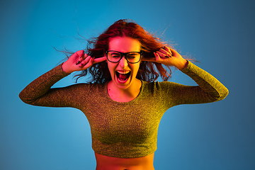 Image showing Caucasian woman\'s portrait isolated on blue studio background in neon light