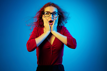 Image showing Caucasian woman\'s portrait isolated on blue studio background in neon light