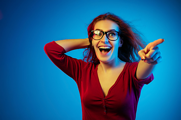 Image showing Caucasian woman\'s portrait isolated on blue studio background in neon light